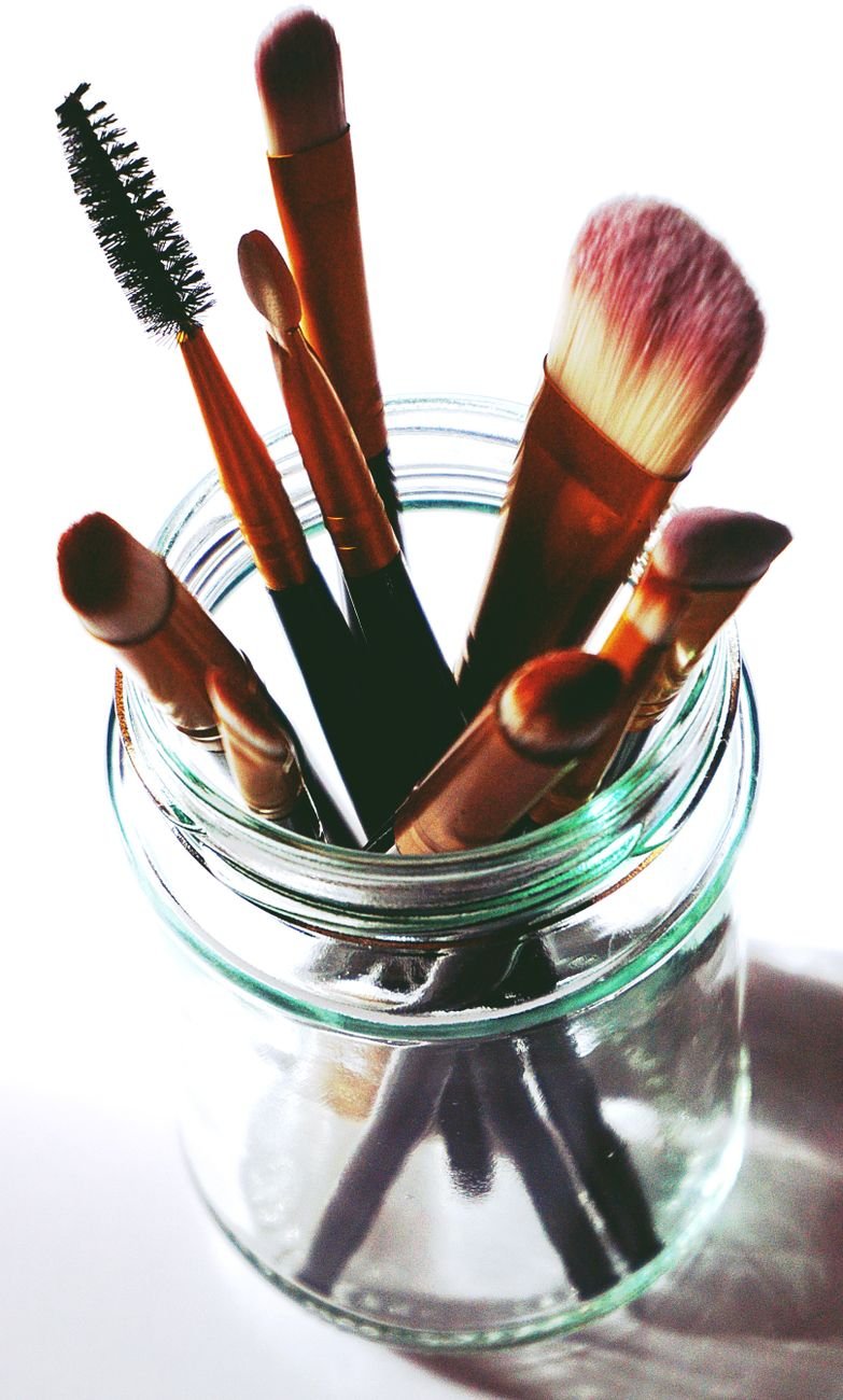 brown makeup brushes in clear glass mason jar