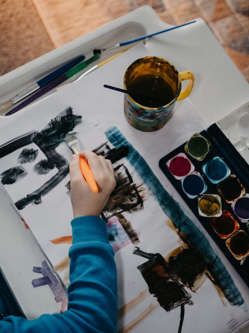 child painting with watercolors on canvas